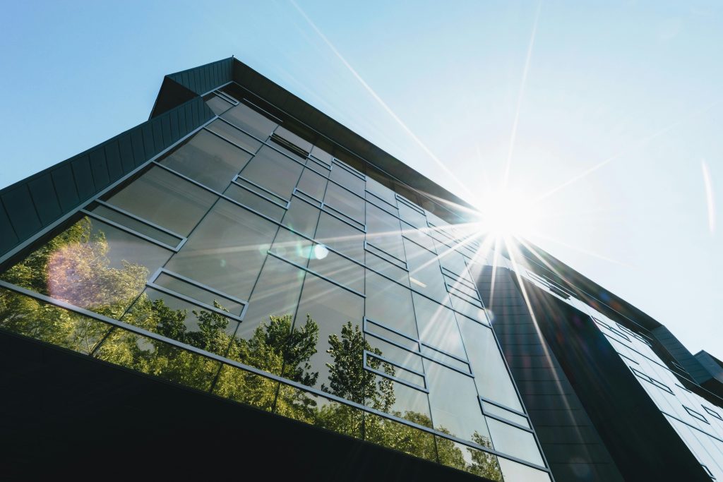 pexels-photo-305833-305833 Low angle view of a modern skyscraper with reflections and sun flare, emphasizing contemporary architecture.