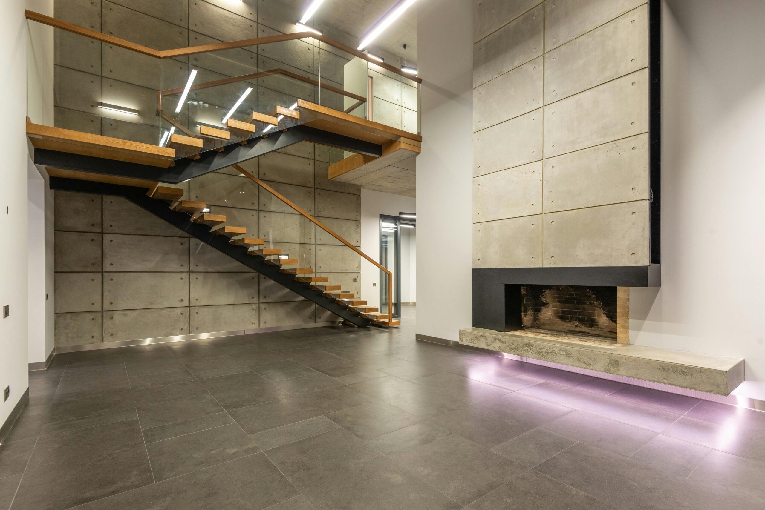 Spacious modern interior featuring a minimalist staircase and fireplace.